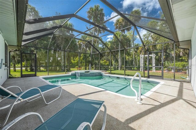 view of pool with a lanai, a pool with connected hot tub, and a patio