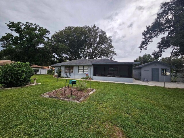 back of property featuring a lawn and a sunroom