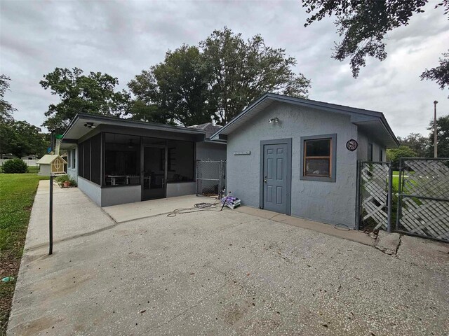 rear view of property featuring a patio and a sunroom