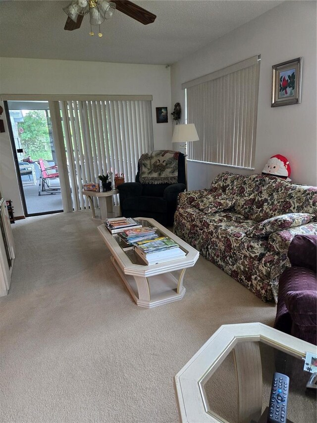 living room featuring a textured ceiling, ceiling fan, and carpet