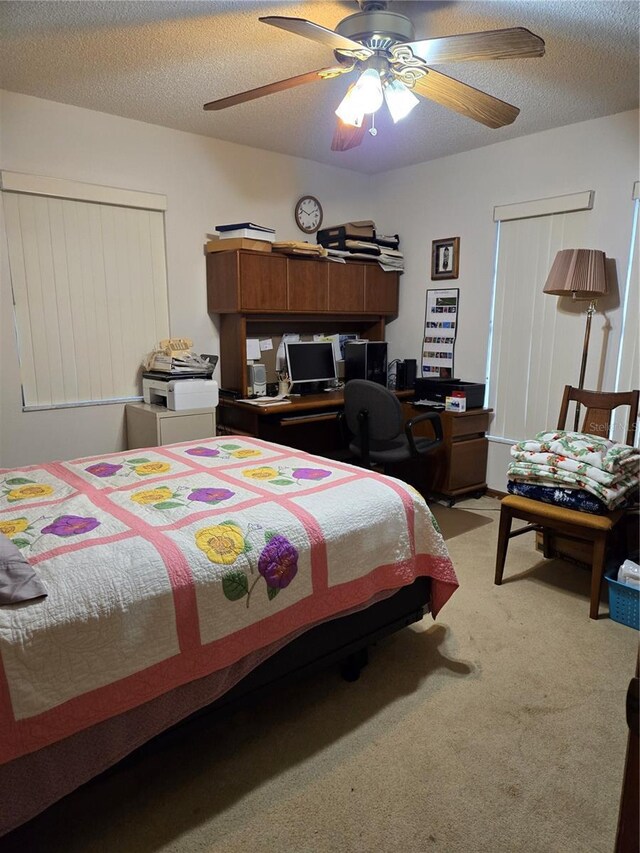 carpeted bedroom with ceiling fan and a textured ceiling