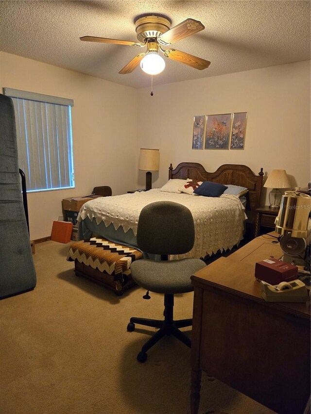 carpeted bedroom featuring ceiling fan and a textured ceiling