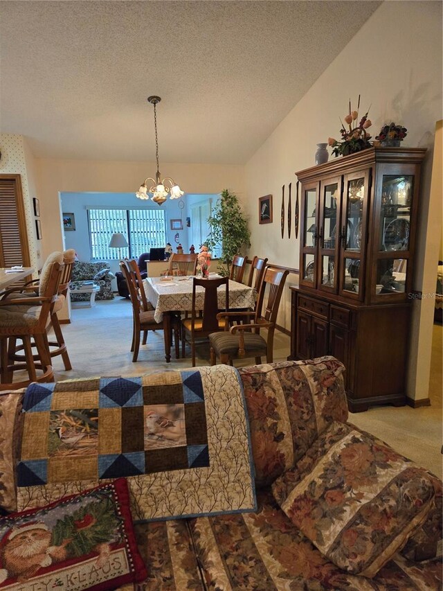 dining area with light colored carpet, a chandelier, vaulted ceiling, and a textured ceiling