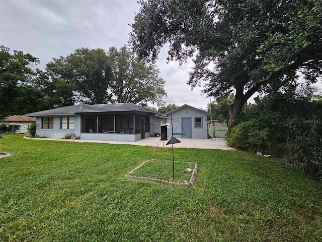 rear view of property with a yard, a patio area, and a sunroom