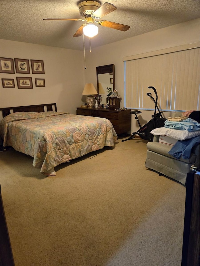 bedroom featuring ceiling fan, carpet flooring, and a textured ceiling