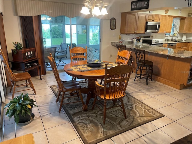 tiled dining space featuring sink and a notable chandelier