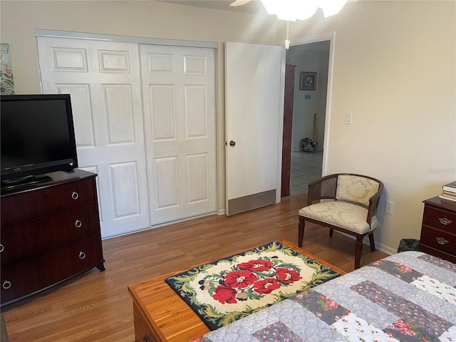 bedroom with wood-type flooring, ceiling fan, and a closet