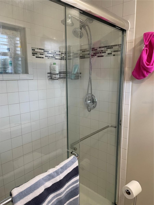 bathroom with a shower with door