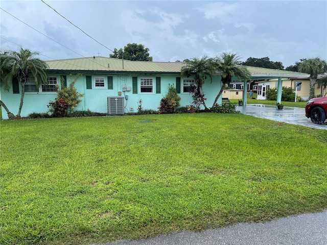 single story home featuring cooling unit and a front lawn