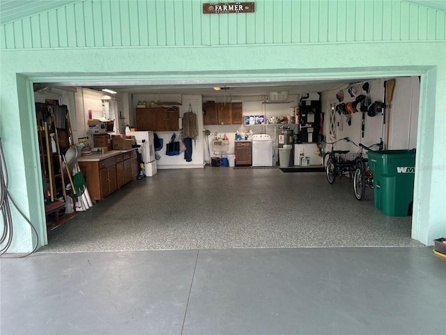 garage with washer and clothes dryer and electric water heater