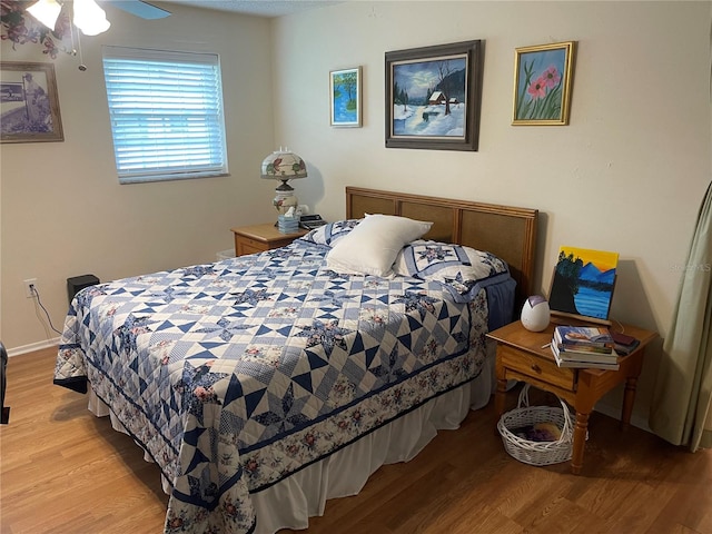 bedroom with ceiling fan and light hardwood / wood-style floors