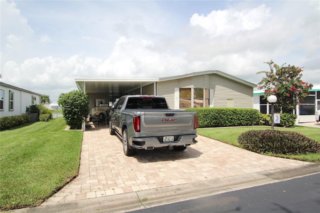 manufactured / mobile home featuring a carport and a front yard