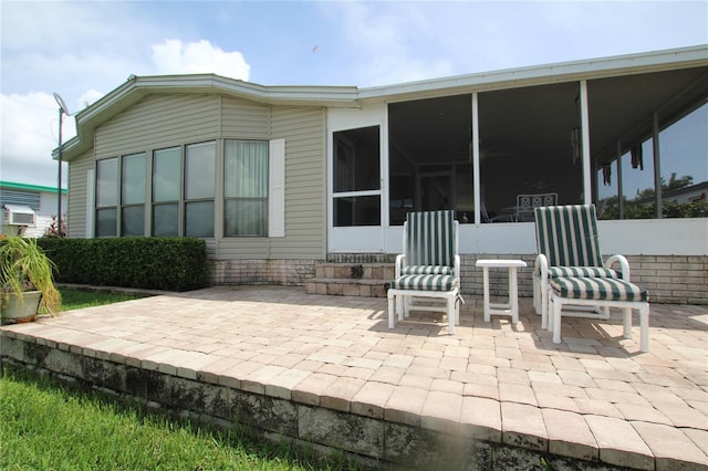 back of property with a sunroom and a patio