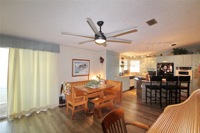 dining area featuring a textured ceiling, ceiling fan, and dark hardwood / wood-style flooring