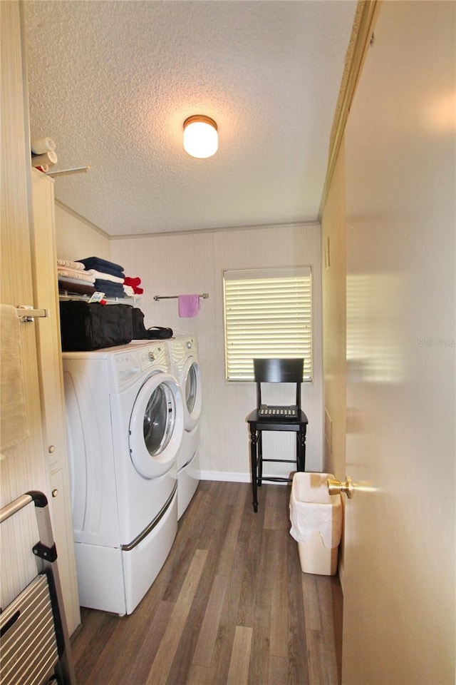 laundry area with dark wood-type flooring, crown molding, washer and clothes dryer, and a textured ceiling