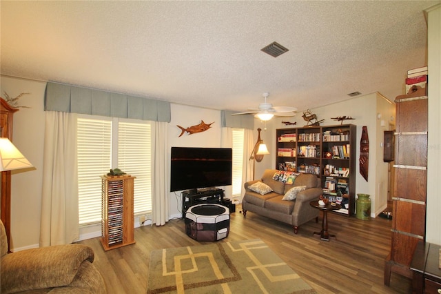 living room featuring a textured ceiling, ceiling fan, and hardwood / wood-style flooring