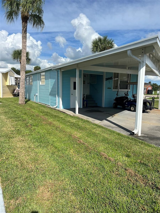 rear view of house featuring a yard and a carport