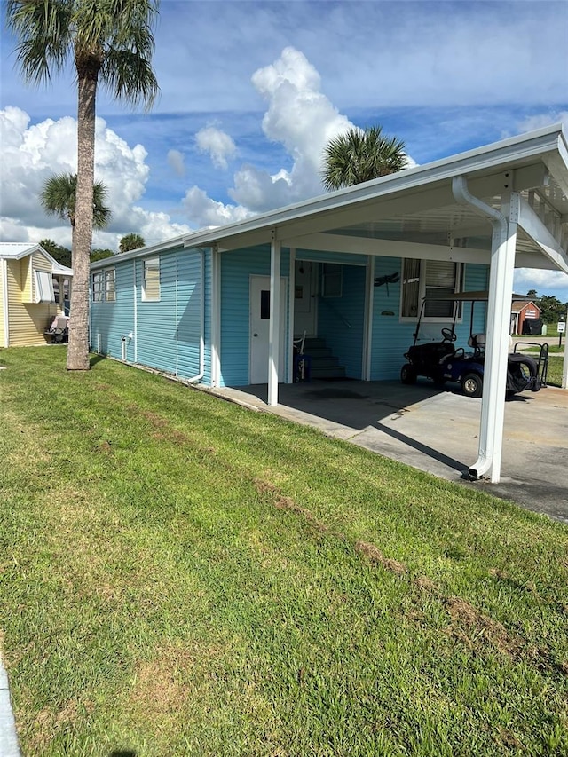 6697 SE 51st Ln Iii, Unit Iii, Okeechobee, FL 34974 - back of house featuring a carport and a yard