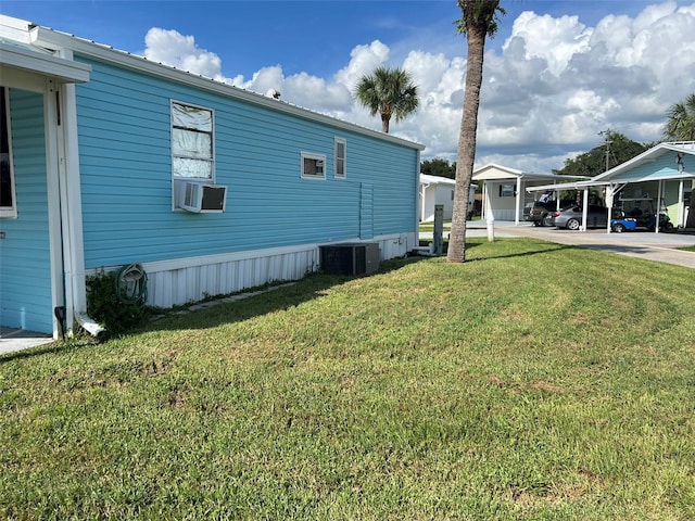 view of yard with central AC unit and a carport