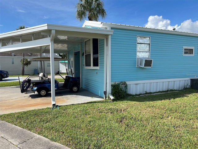 6697 SE 51st Ln Iii, Unit Iii, Okeechobee, FL 34974 - view of side of home with a lawn, cooling unit, a carport, and concrete driveway