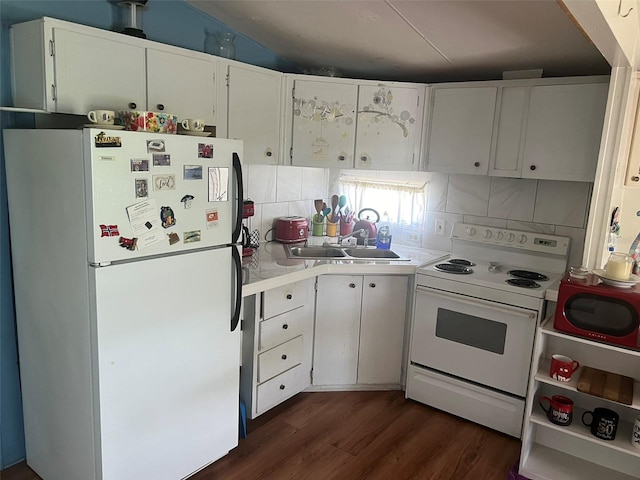 kitchen featuring white appliances, dark wood-type flooring, sink, lofted ceiling, and white cabinets