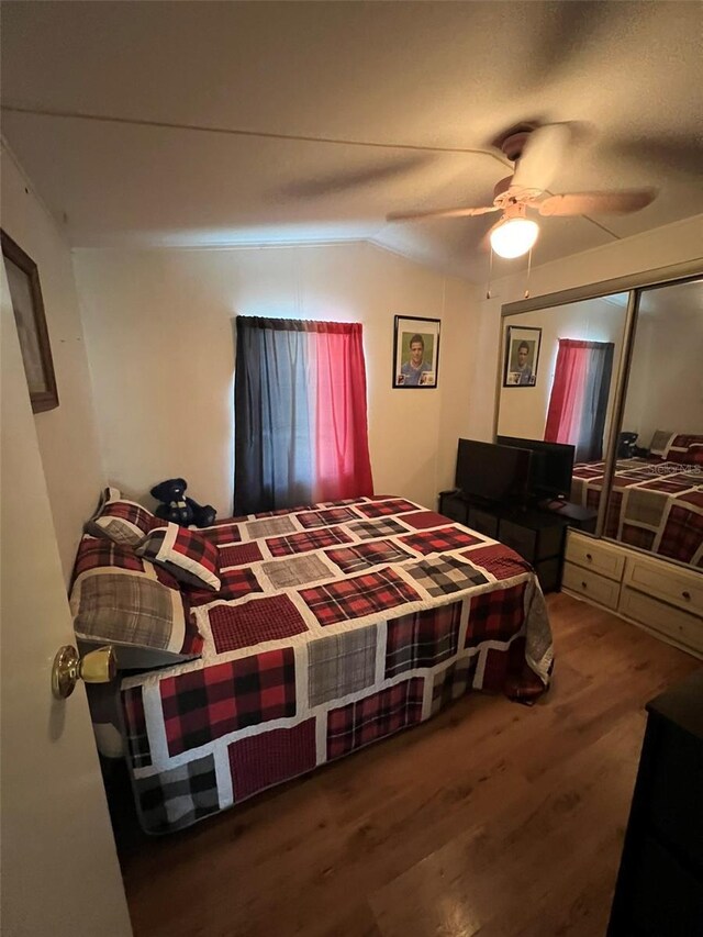 bedroom with lofted ceiling, hardwood / wood-style floors, and ceiling fan