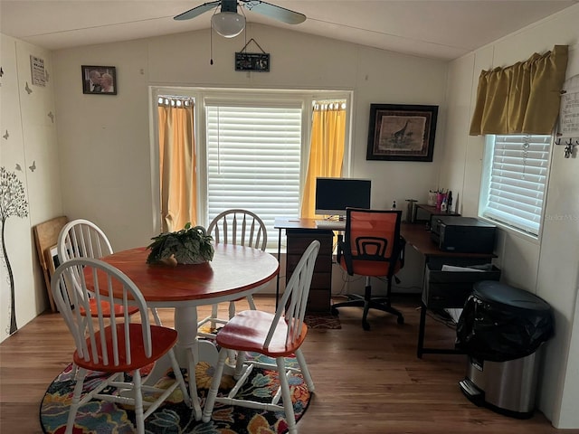 dining space with hardwood / wood-style floors, ceiling fan, and vaulted ceiling