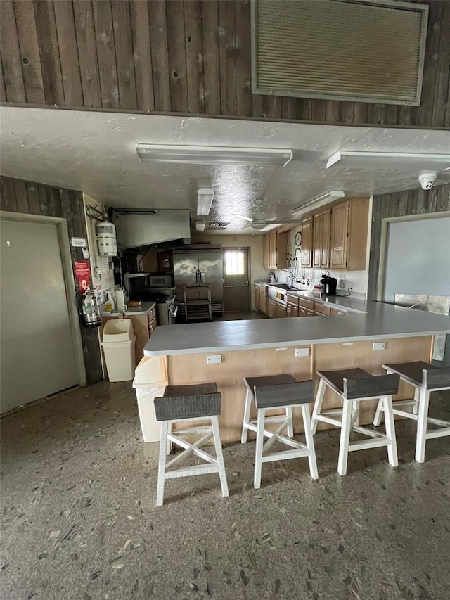 6697 SE 51st Ln Iii, Unit Iii, Okeechobee, FL 34974 - kitchen featuring a peninsula, a kitchen bar, and wooden walls
