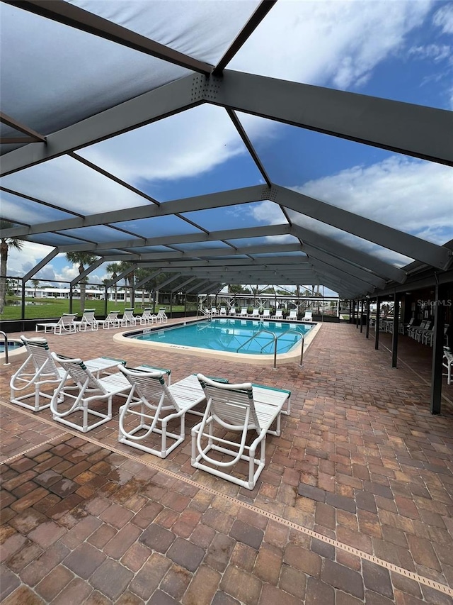 view of swimming pool featuring a patio area and a lanai