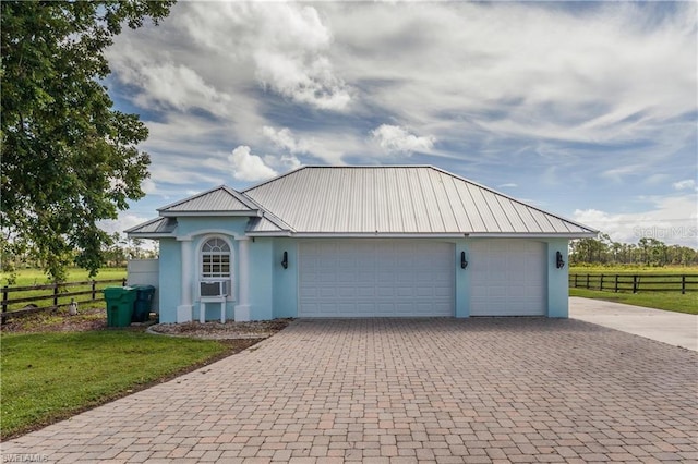 view of front of home featuring cooling unit, a front lawn, and a garage