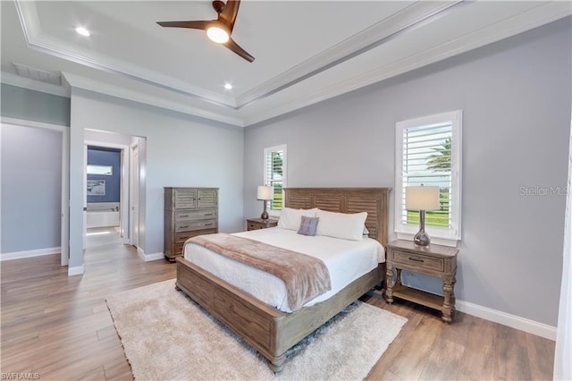 bedroom featuring a tray ceiling, ceiling fan, light hardwood / wood-style floors, and ornamental molding