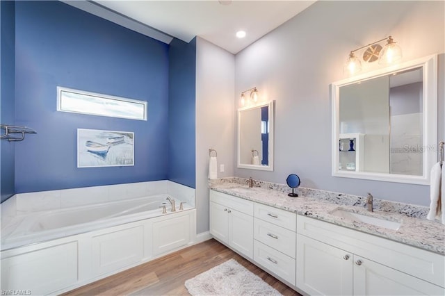 bathroom featuring vanity, a bathing tub, and wood-type flooring