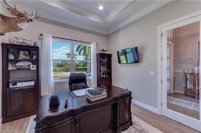 office area featuring crown molding, a tray ceiling, and light hardwood / wood-style floors