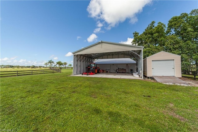 exterior space featuring an outdoor structure, a rural view, a garage, and a carport