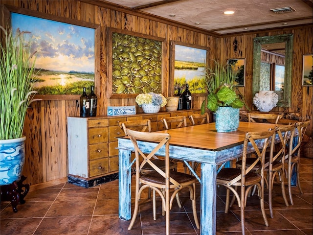 tiled dining room featuring wood walls