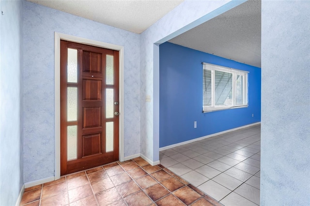 tiled entrance foyer featuring a textured ceiling and a healthy amount of sunlight