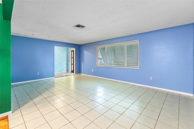 unfurnished room with light tile patterned floors and a textured ceiling