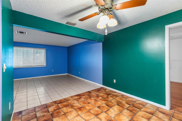 tiled spare room with ceiling fan and a textured ceiling