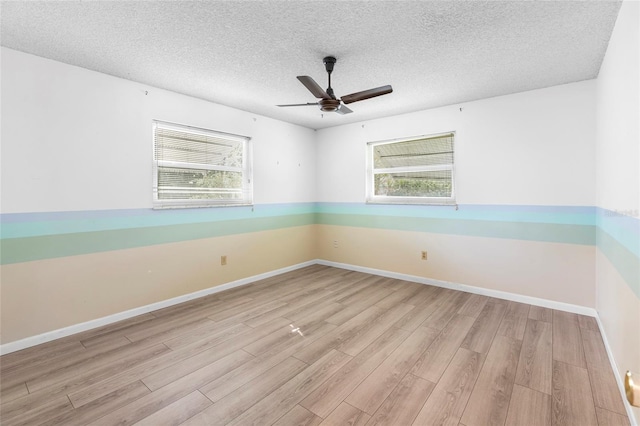 unfurnished room featuring a textured ceiling, light hardwood / wood-style flooring, and plenty of natural light