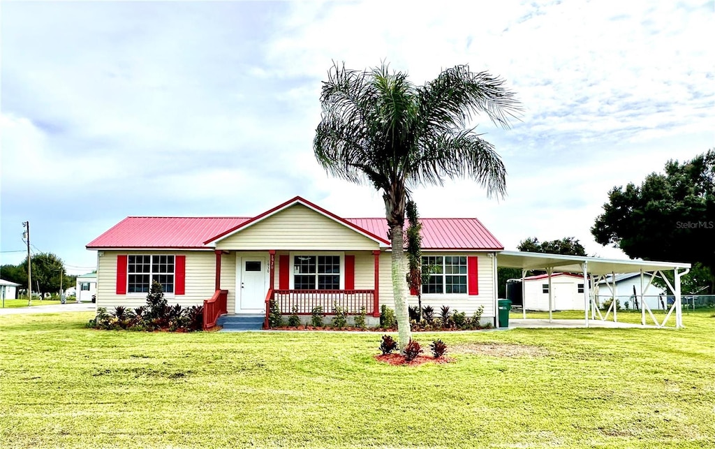 ranch-style house featuring a carport, a porch, and a front lawn