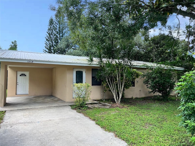 view of front of property with a front lawn and a carport