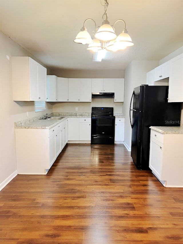 kitchen with white cabinets, dark hardwood / wood-style flooring, a chandelier, and black appliances