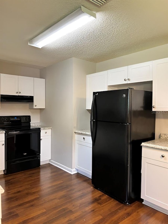 kitchen with dark wood-type flooring, white cabinets, black appliances, and a textured ceiling