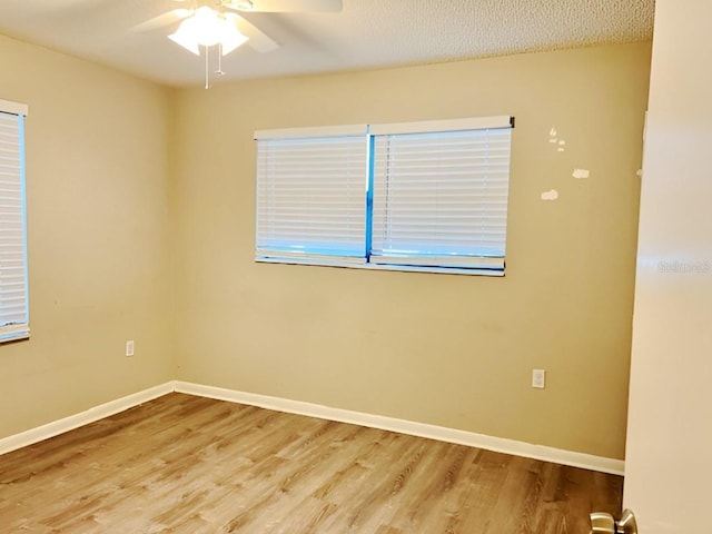 empty room with ceiling fan, a textured ceiling, and light wood-type flooring