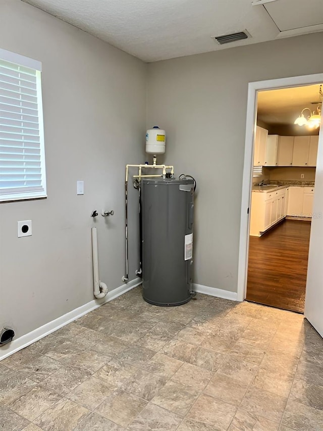 utility room featuring sink and water heater