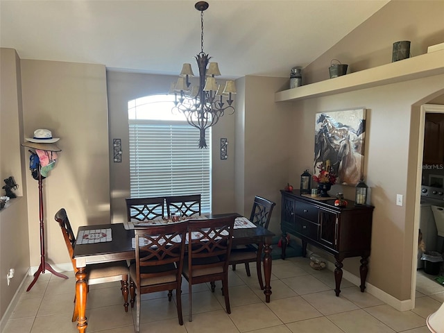 tiled dining area featuring lofted ceiling and an inviting chandelier