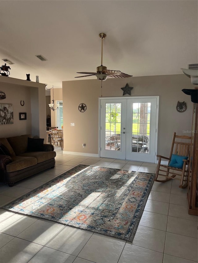 living room with french doors, light tile patterned floors, and ceiling fan with notable chandelier