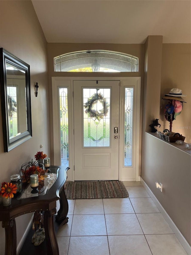 tiled foyer featuring vaulted ceiling and plenty of natural light