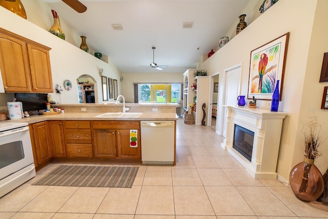 kitchen featuring kitchen peninsula, sink, light tile patterned floors, white appliances, and ceiling fan