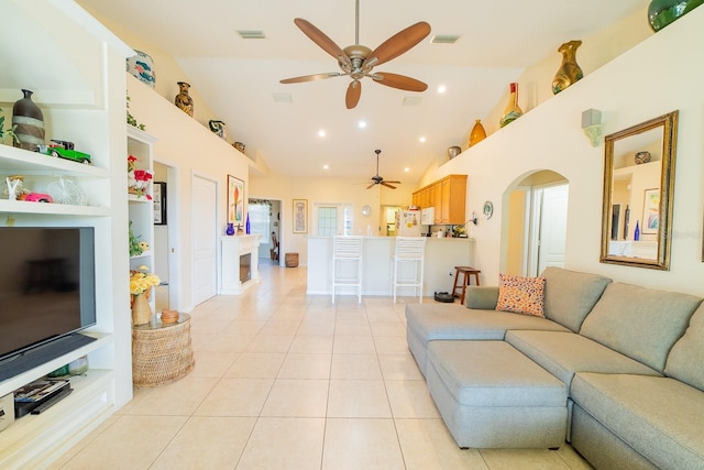 tiled living room with built in shelves, high vaulted ceiling, and ceiling fan